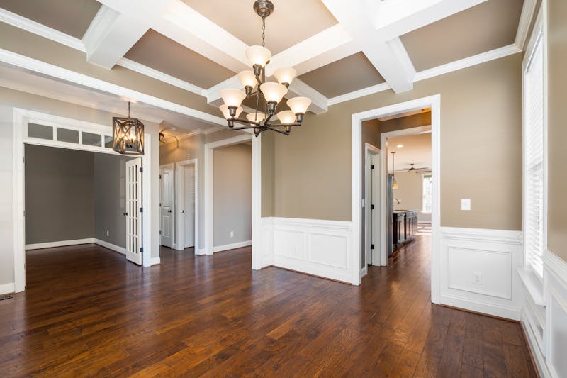 Elegant room showcasing hardwood floors with chandelier and wainscoting