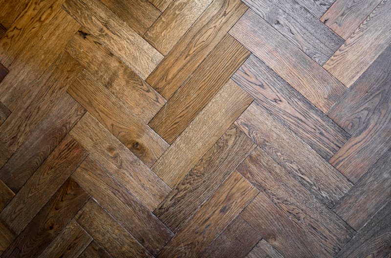 Herringbone parquet floor pattern in warm walnut tones