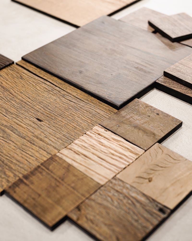 Assorted wooden tiles arranged on floor showing intricate parquet pattern